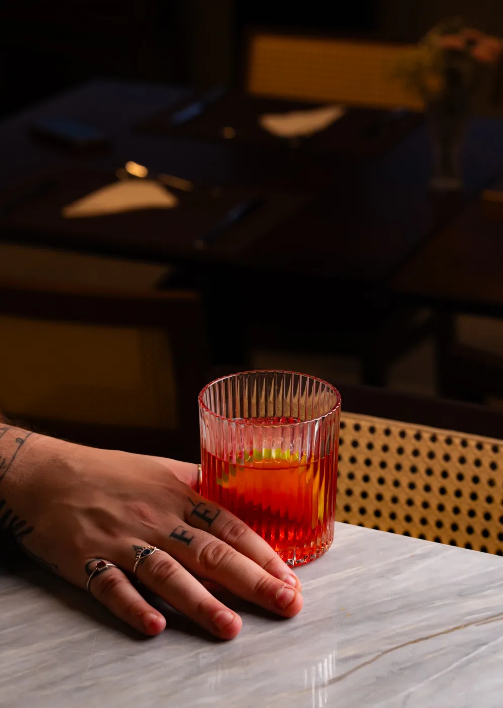 Drink autoral em copo sobre bancada de mármore